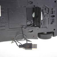 Close-up of a black electronic device with USB cable on a white background