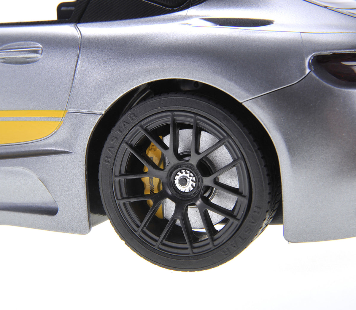 Close-up of a car wheel with a black rim and yellow accents on a silver car.