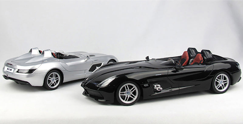 Two sports cars, one silver and one black, on a white background