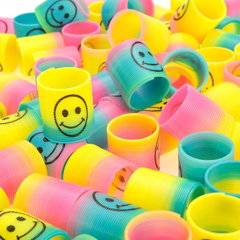 Pile of Colorful Mini Rainbow Emoticon Coil Springs - playful collection of toy springs with smiley faces.