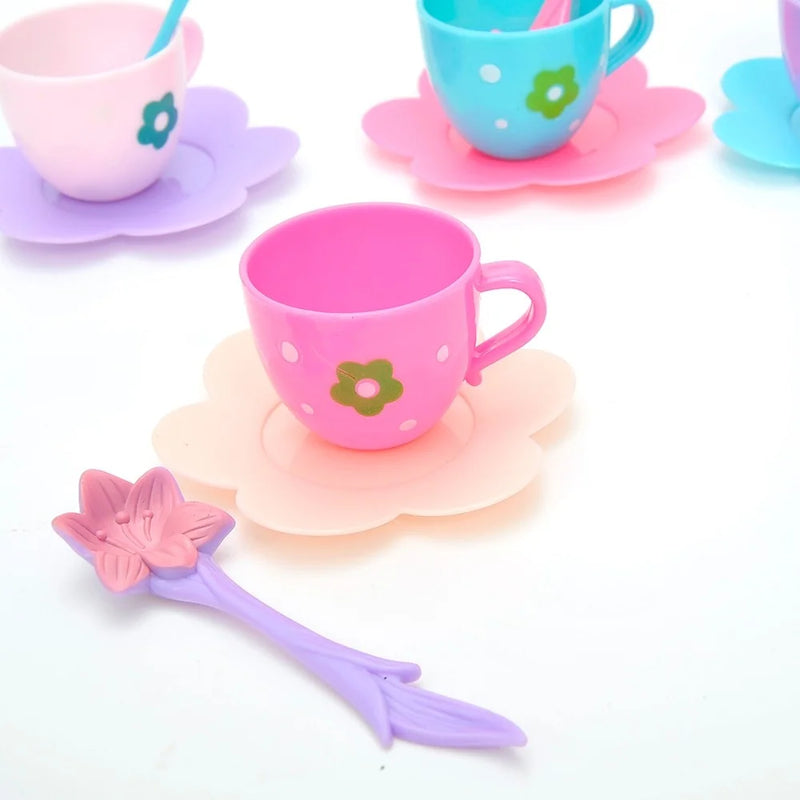 Pink toy tea cup with floral design and matching purple spoon for toddler pretend tea party set.