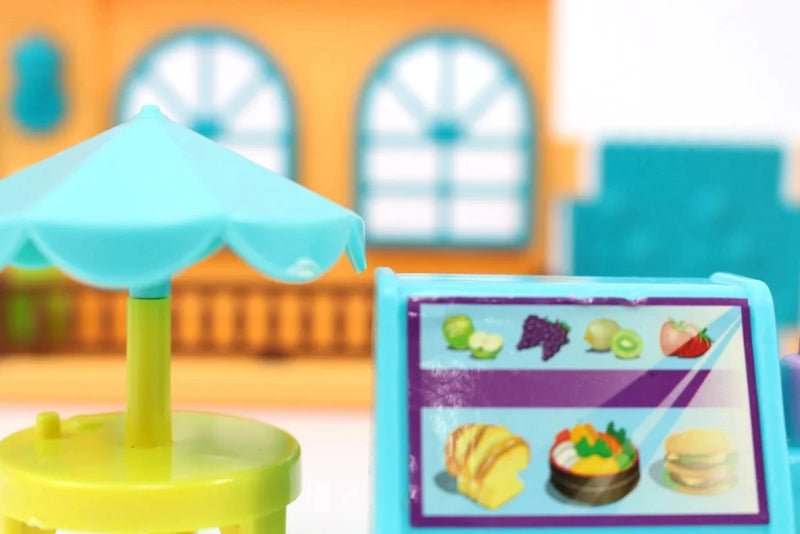 Close-up of small doll house furniture set including tables, chairs, and counter for doll play