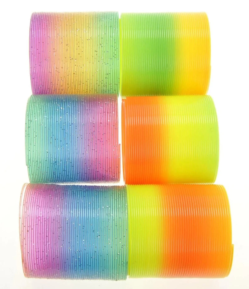 Stacked plastic rainbow springs in various colors, including orange, yellow, green, and glittered rainbow, ideal for children.