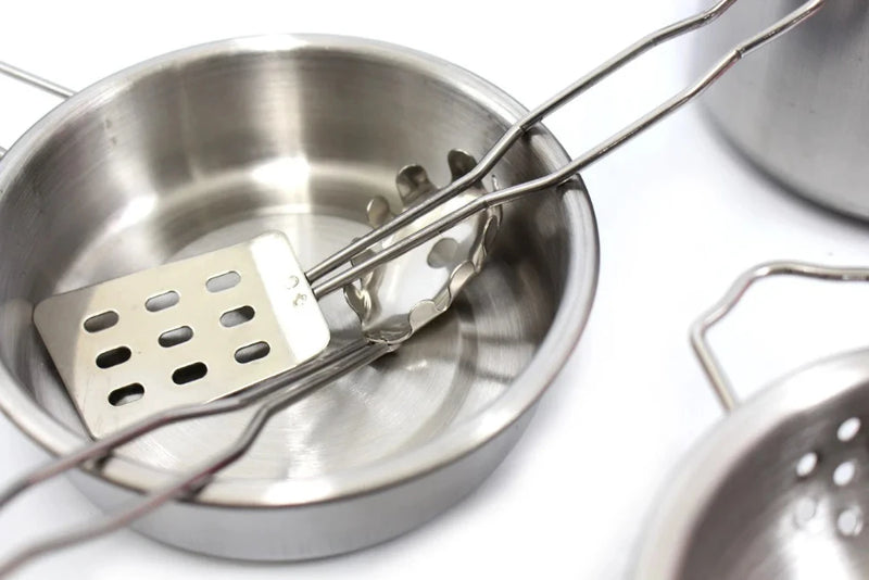 Stainless steel frying pan with a spatula and tongs, included in a children's kitchen play set