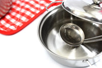 Close-up of a stainless steel pot with a ladle, part of a kitchen play set for kids