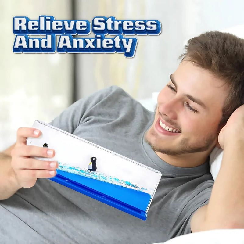 Man relaxing with a liquid motion penguin sensory toy, designed for stress relief and anxiety reduction