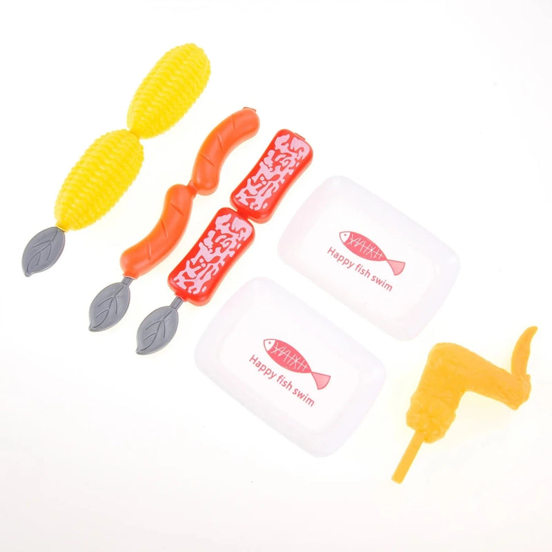 Toy grill with corn, sausage, and chicken pieces for pretend cooking.
