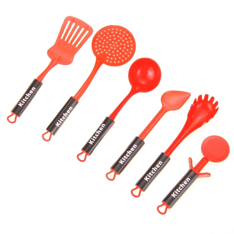Close-up of toy kitchen frying pan with egg, kettle, pot, and cooking utensils