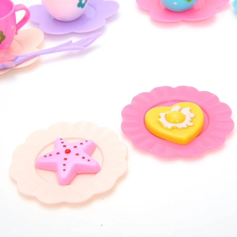 Toy tea party set with starfish and heart-shaped cookies on colorful plates for toddler play.